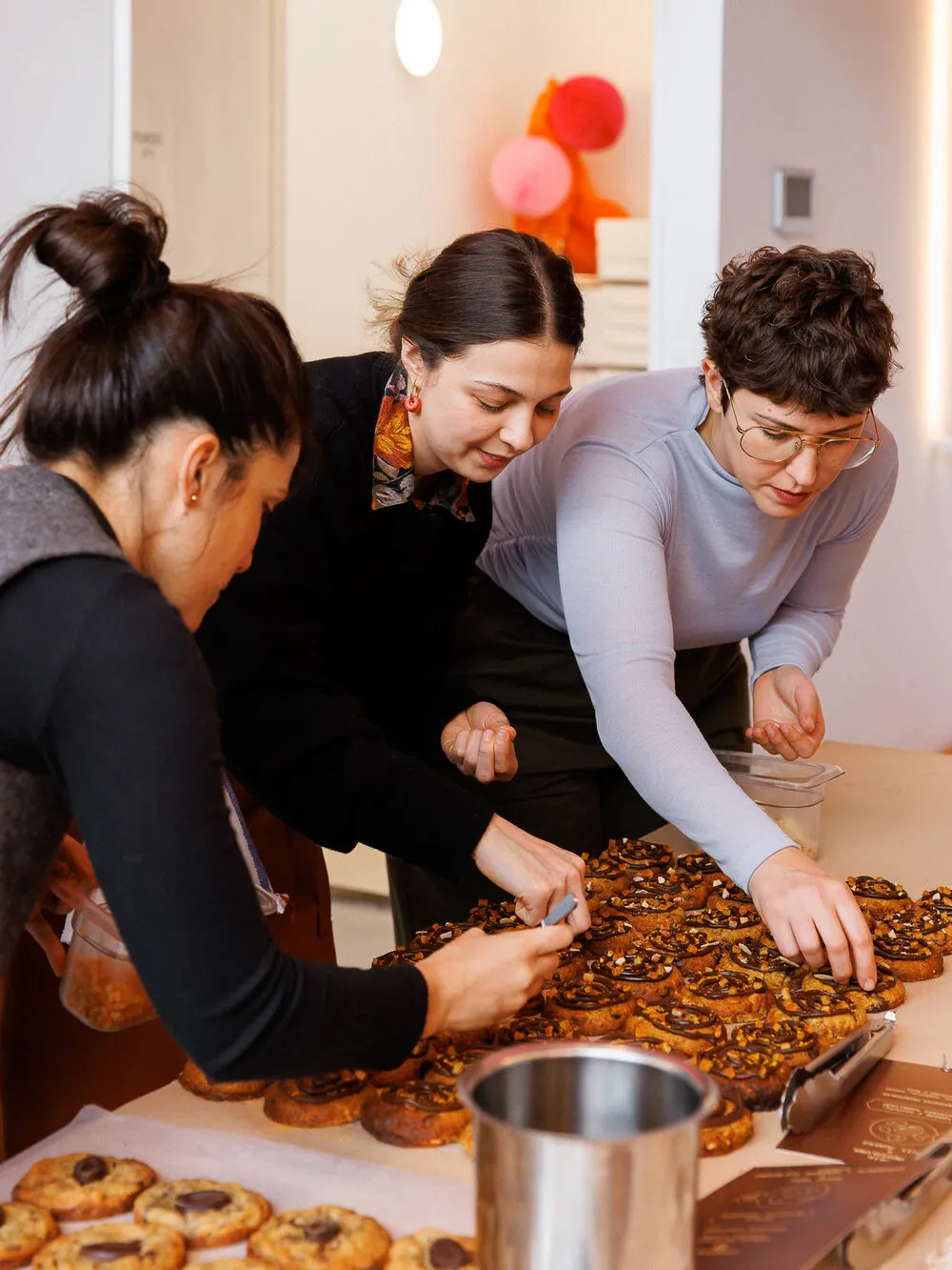 Pasteleras decorando cookies juntas antes del evento