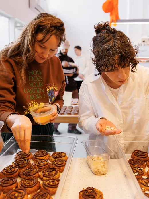 Dos pasteleras terminando cookies con espiral de chocolate y almendras