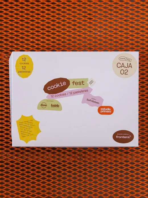 Caja de Cookie Fest, primera edición, sobre una reja naranja